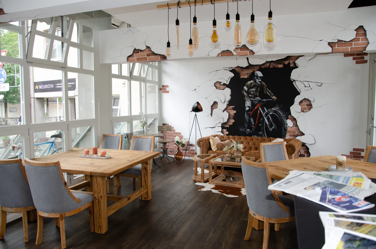 Man sieht ein Bistro von inne mit Tischen und Stühlen.